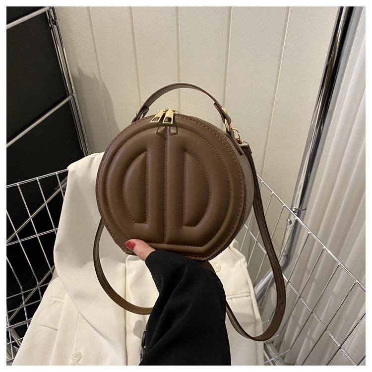 

This year s popular niche design bag 2024 autumn new simple fashion messenger bag casual portable small round bag темно-коричневого кольору