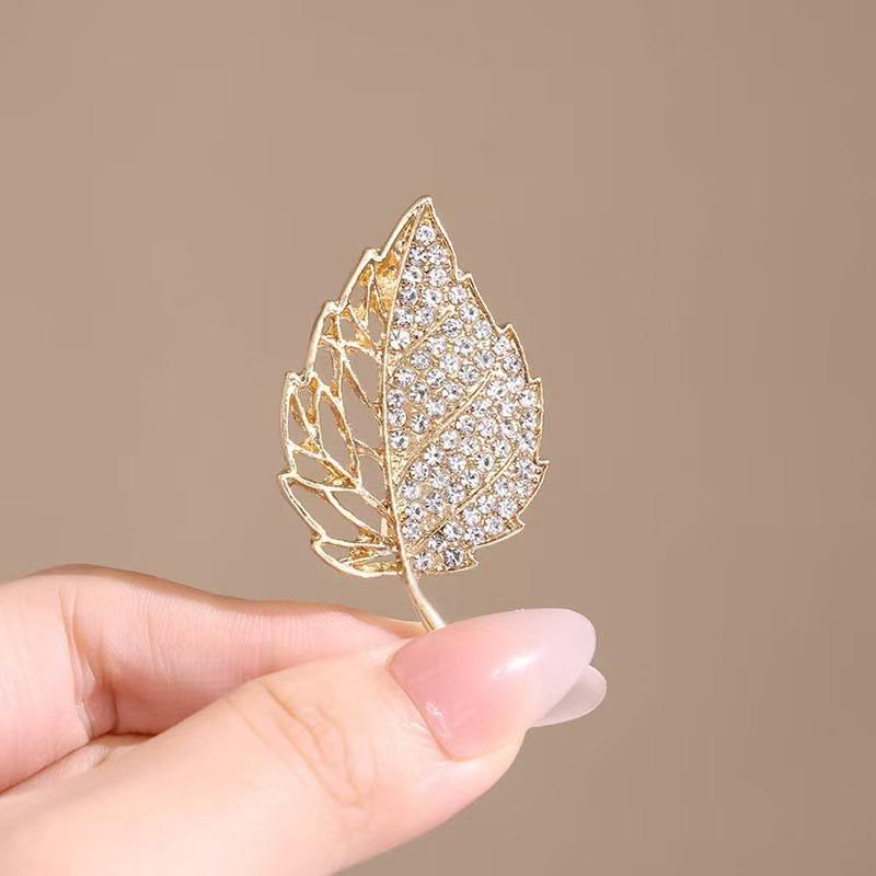 

Роскошная сверкающая брошь в виде золотого листа, инкрустированная бриллиантами, раскрывает изысканный элегантный стиль, демонстрируя высококлассную текстуру и изысканность.