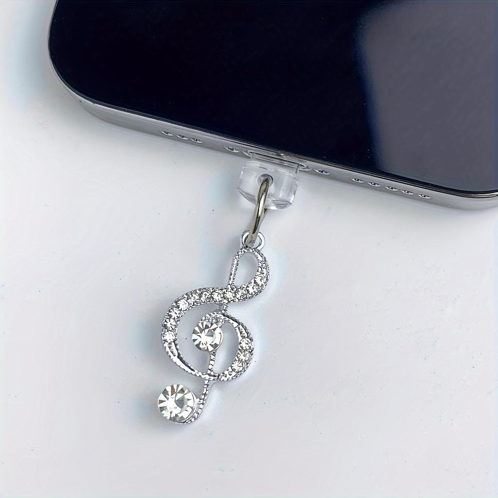 Chraňte svůj telefon stylovou zlatou prachovou zátkou ve tvaru hudební noty, ozdobte svůj telefon závěsným popruhem.