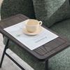 Modern single armchair with comfortable fabric backrest and two storage compartments, complemented by a practical side table.