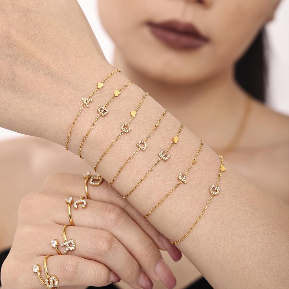 Oumeika Titanium Steel Jewelry Set: 26 Zircon-Inlaid Letters, PVD Gold-Plated Necklace, Bracelet, Earrings, and Ring.