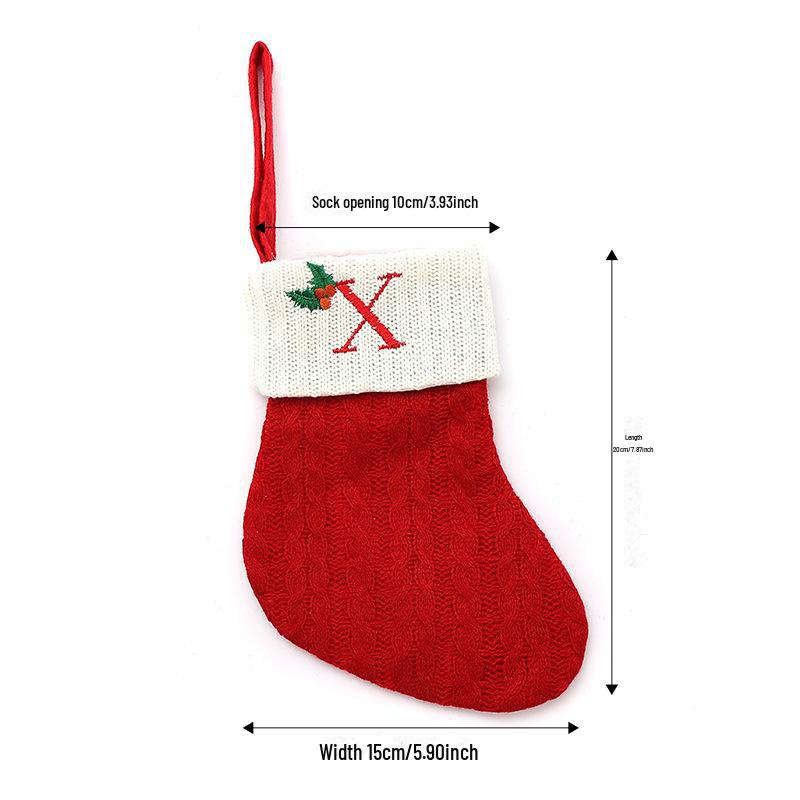 Weihnachtsdekorationen: Rote gestrickte Kinderstrümpfe mit gestickten Buchstaben