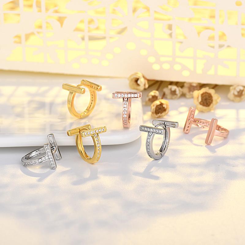 Modne kolczyki sztyfty z podwójnym T i pełnym diamentem, złote, luksusowe, z literą wykonaną techniką czystego igłowania