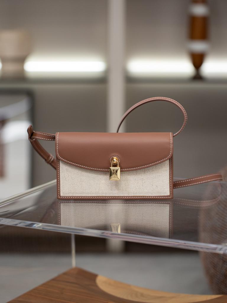 A Small Square Canvas Women's Bag with a Unique Lock and a Light Luxury Style Made of Cowhide