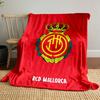 A crowned emblem with yellow circular patterns on a red background. for all seasons blanket lunch break throw gift