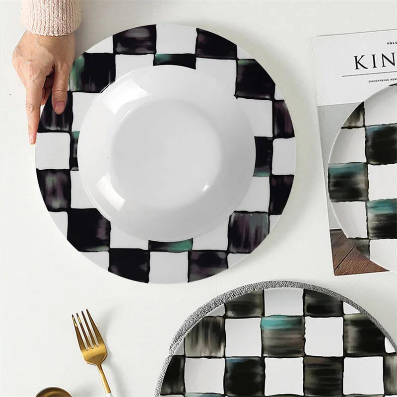 Piatto piano in ceramica a scacchi bianco e nero Tazza da caffè e piattino in bone china Piatti per cibi occidentali Stoviglie eleganti per la casa Tazza