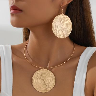 Velké kulaté náušnice a náhrdelník v přehnaném stylu s tepanými vlnkami a elegantními šperky