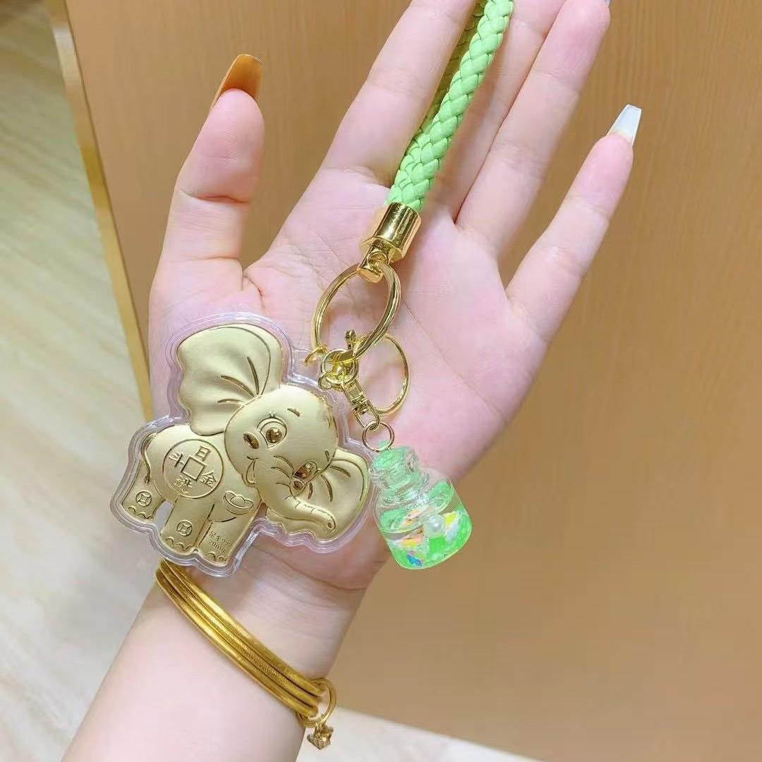 Золотой подвес-мобиль «Счастливый слон»: Брелок из чистого золота 999 пробы с подвеской в виде бутылочки для загадывания желаний. Contains 20mg Gold