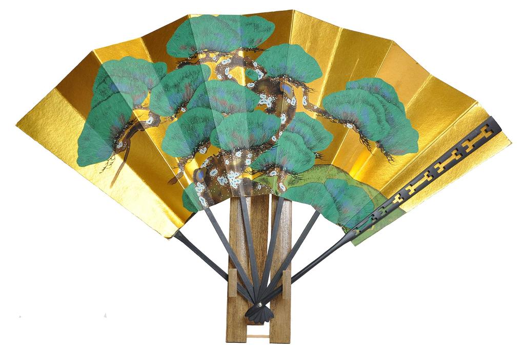 Tendai-style carved decorative fan with pine tree design and fan stand.