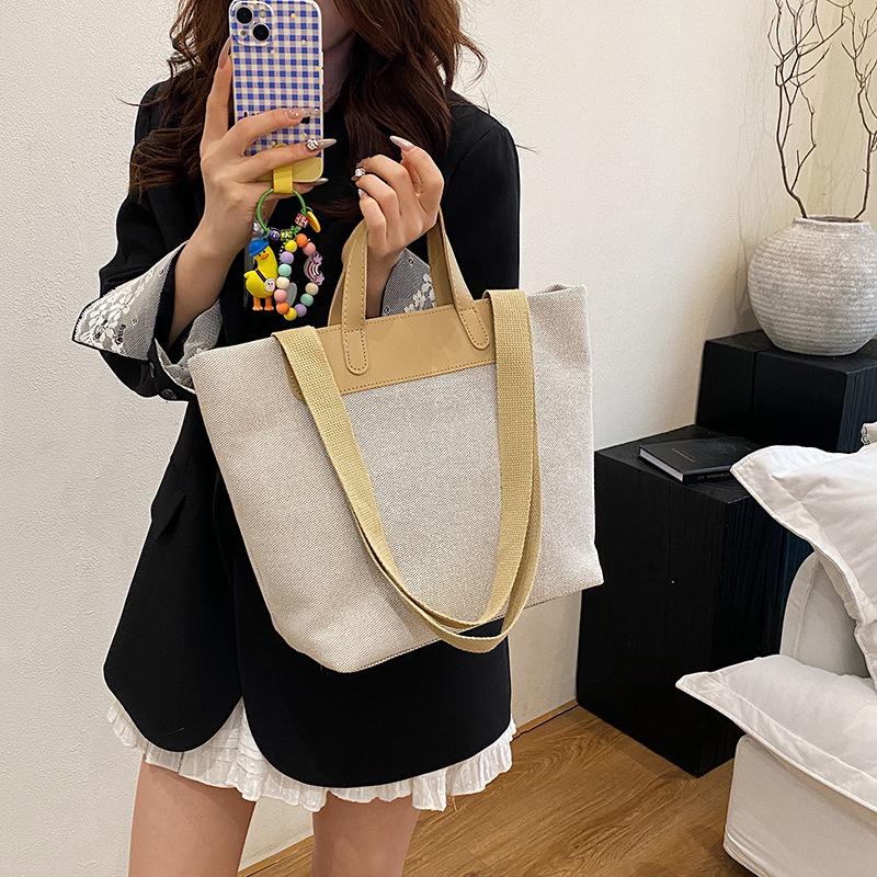 Fritid och konst splicing canvas 2025 vävning enkel ny temperament pendling mode tote bärbar axelväska