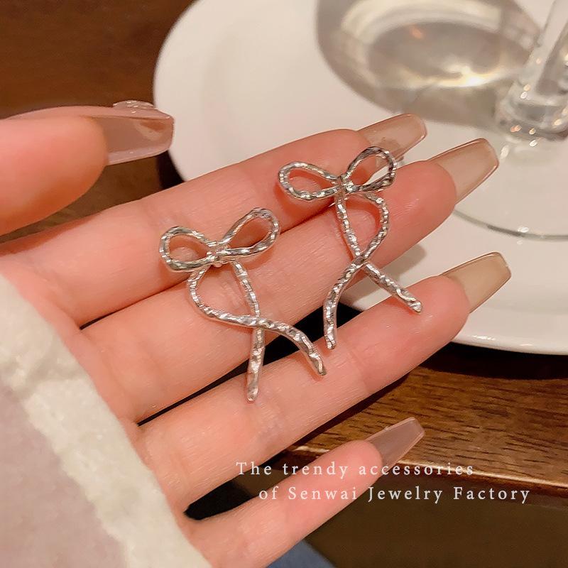 

Ballet style metal silver bow earrings women s design sense niche simple temperament stud earrings Spice girl new earrings