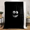 A glowing, cartoonish face with wide eyes and a big toothy grin on black. for all seasons blanket lunch break throw gift