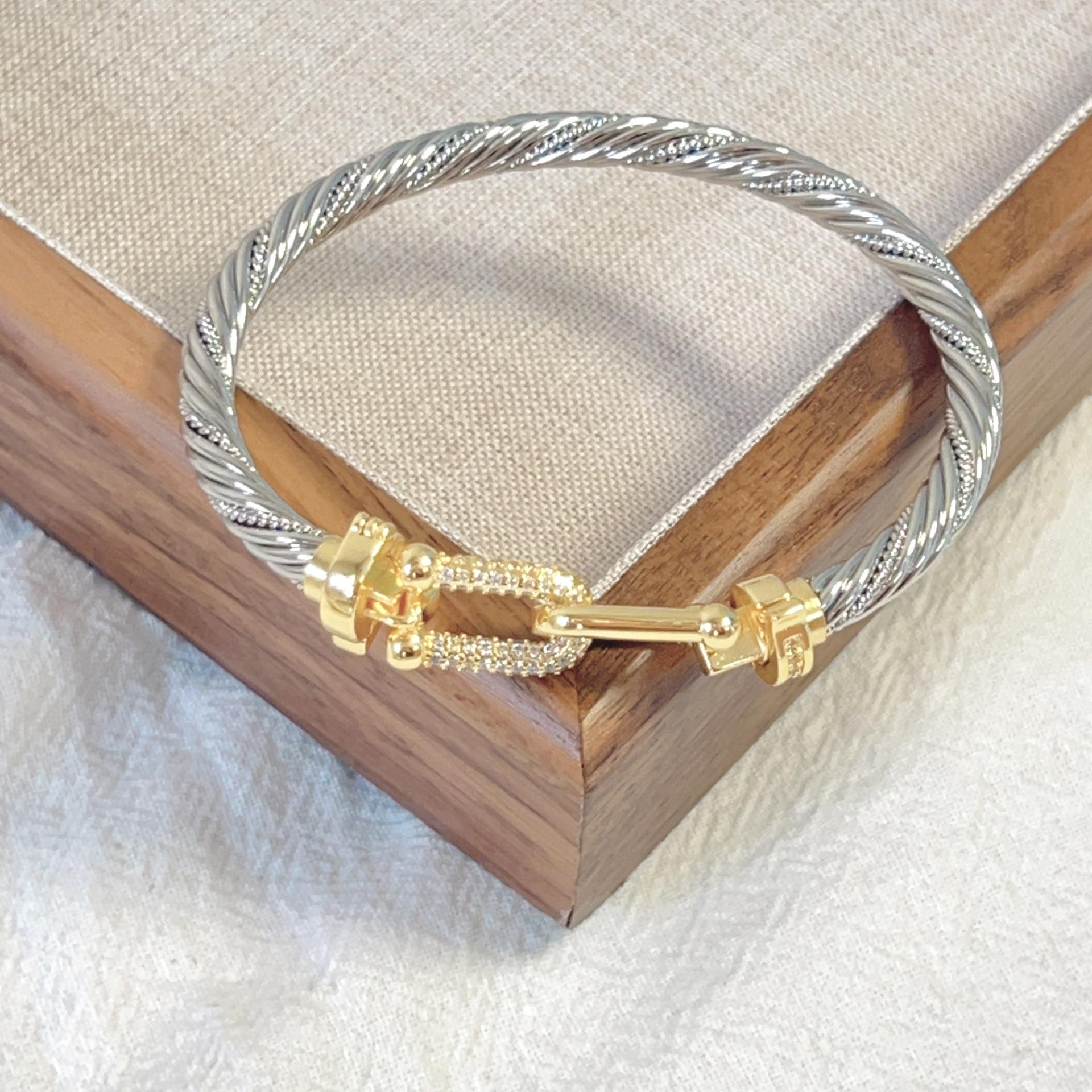 

Браслет из стальной проволоки с застежкой-подковой в виде четырехлистного клевера и микроинкрустацией из 18-каратного золота