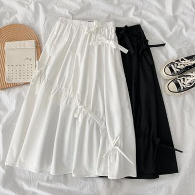 Ασύμμετρη Λευκή Φούστα με Φιόγκο για Γυναίκες την Άνοιξη και το Καλοκαίρι Νέο Μικρό Σχέδιο Μακριά Φούστα