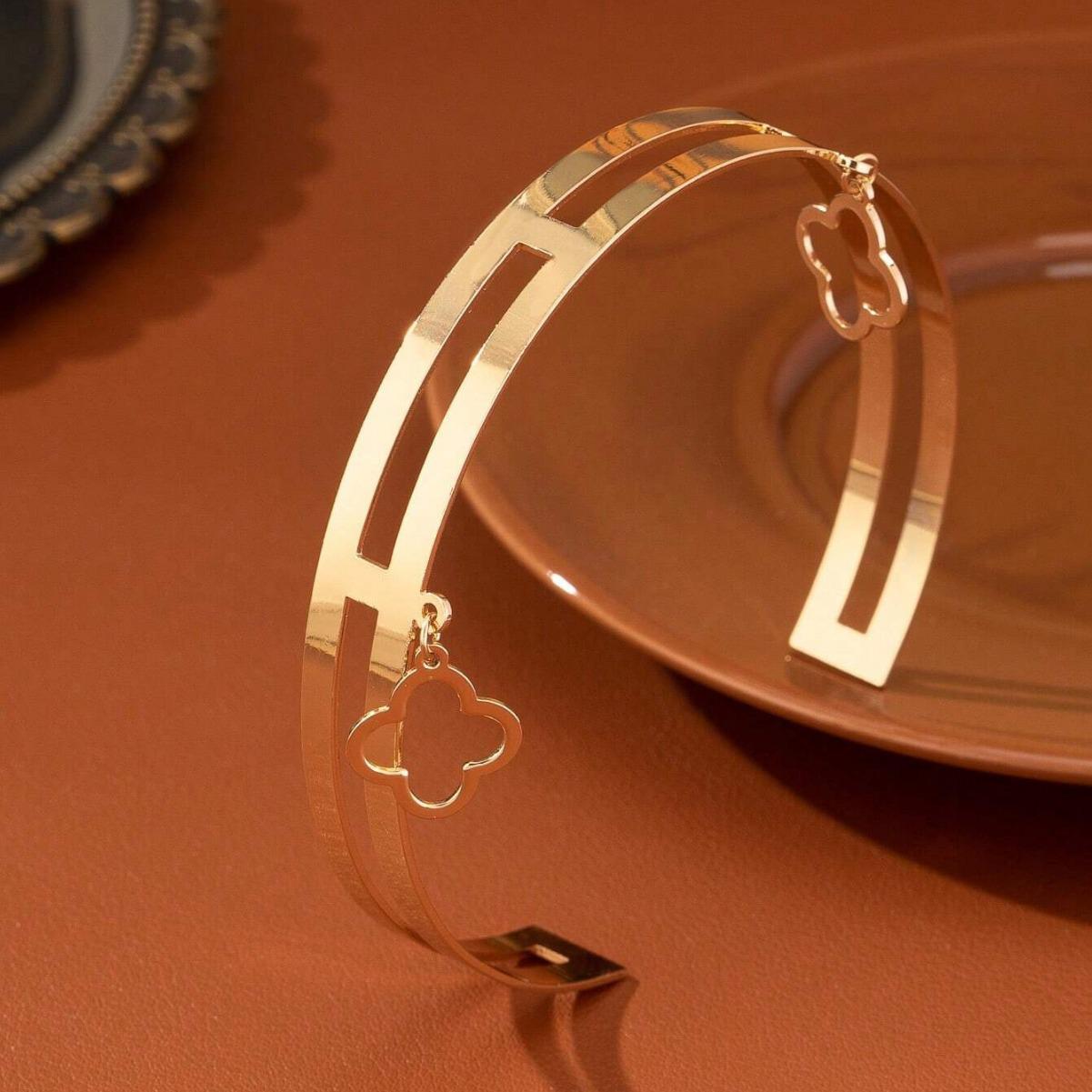 

Браслет-нарукавник с двухслойным полым подвесом в виде цветка золотой