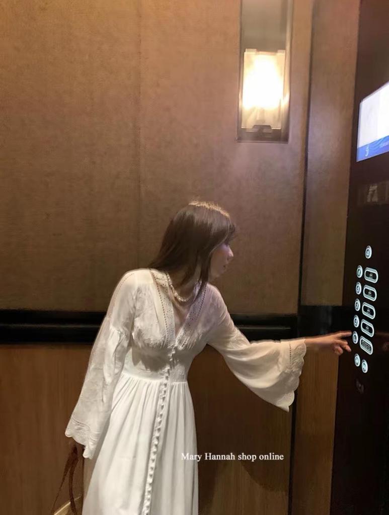 Robe blanche à manches longues et broderie ajourée pour les vacances à l'île ou à la plage