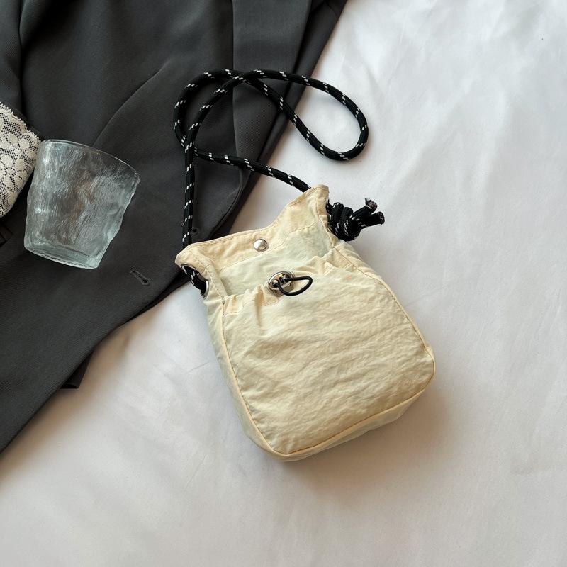 

2025 New Japan and South Korea literary single shoulder messenger bag drawstring small bag niche sense fashion high value mobile phone nylon bag women бежевый