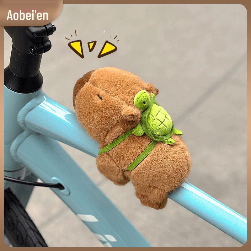 

Плюшевый кулон-капибара с маленькими аксессуарами на велосипедную тематику – украшение-браслет-хлопушка