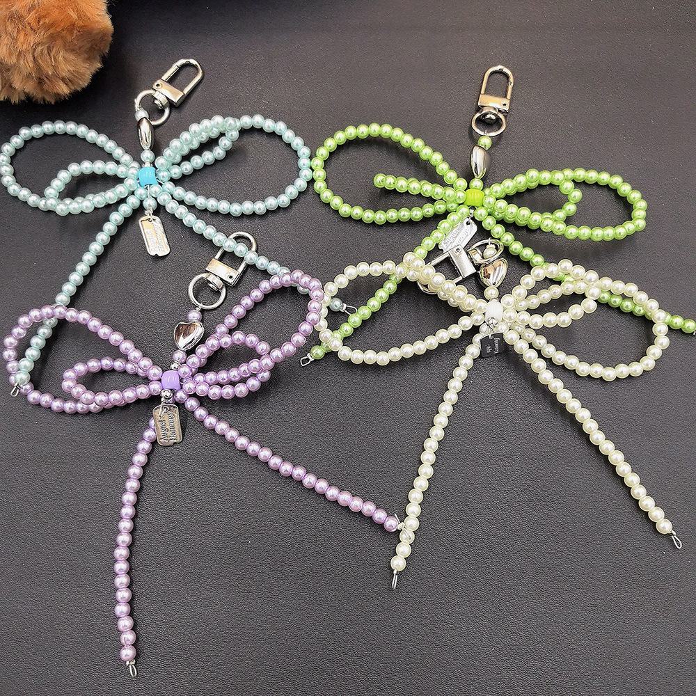 Fashionable Korean-inspired blogger-style large pearl bow mobile phone pendant key chain with heart design.