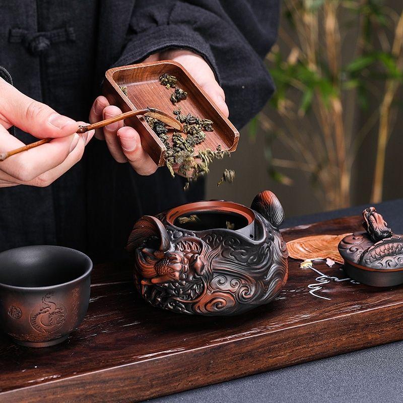 Cerámica púrpura china hecha a mano tallado en relieve dragón volador tetera de agarre manual juego de té de viaje una tetera dos tazas juego de té kung fu