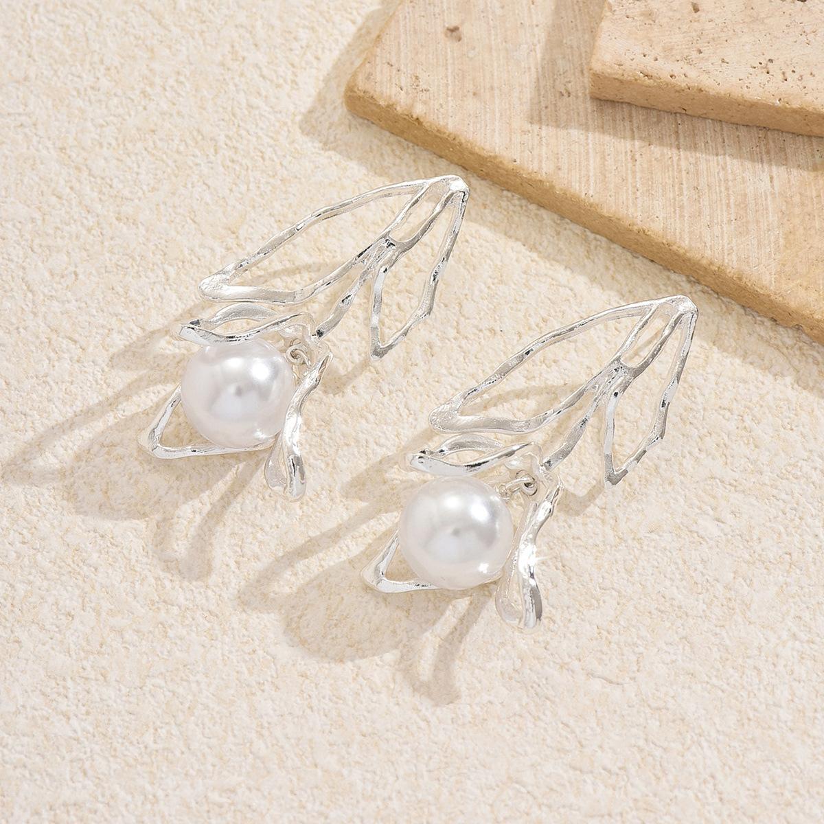 

Pearl stud earrings European and American hollow flower earrings light luxury high sense fresh and sweet design sense exaggerated earrings