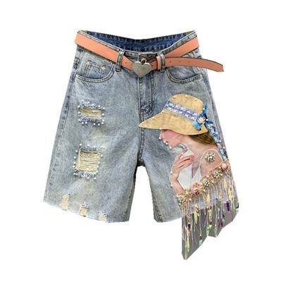 Pantaloncini di jeans da donna alla moda e di tendenza con nappe, paillettes, borchie e buchi
