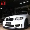 BMW 1 Series E87 Carbon Fiber Exterior Kit: Hood, Front Lip, Headlight Eyebrows, Rear Spoiler, and Rearview Mirrors.