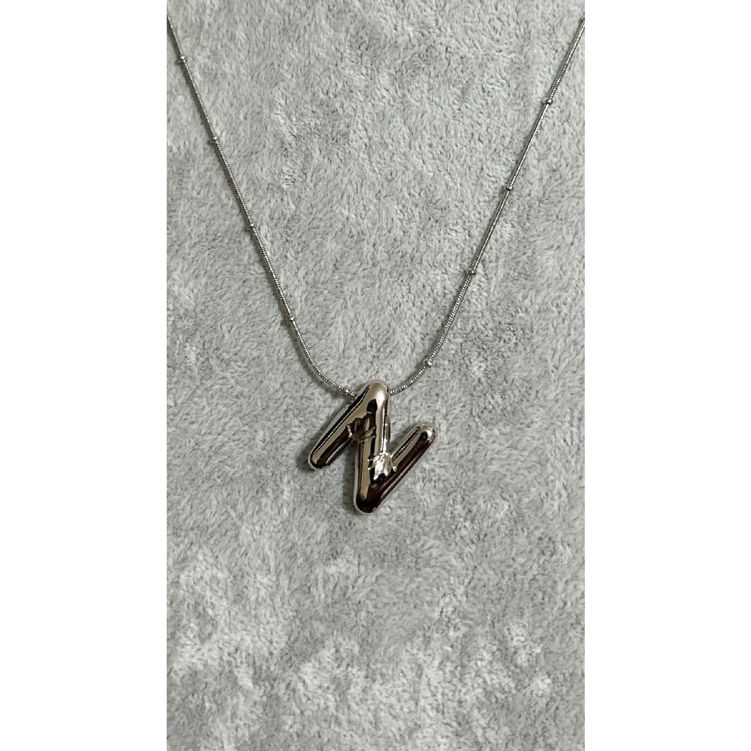 

Женское стальное ожерелье с буквами N и серебряным цветом