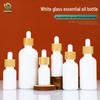 Weiße Glas-Ätherölflasche mit Bambusdeckel und lichtdichter Gummitropfpipette für Kosmetik- und Lotionproben