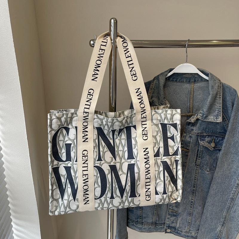 Large capacity alphabet canvas bag women's 2025 new fashion niche shoulder bag college student class commuter bag