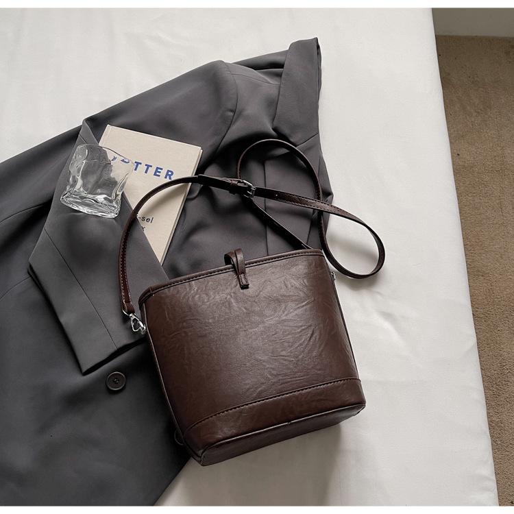 

Small bag women s versatile new simple texture foreign style design messenger bag fashionable work hand carrying bucket bag темно-коричневого
