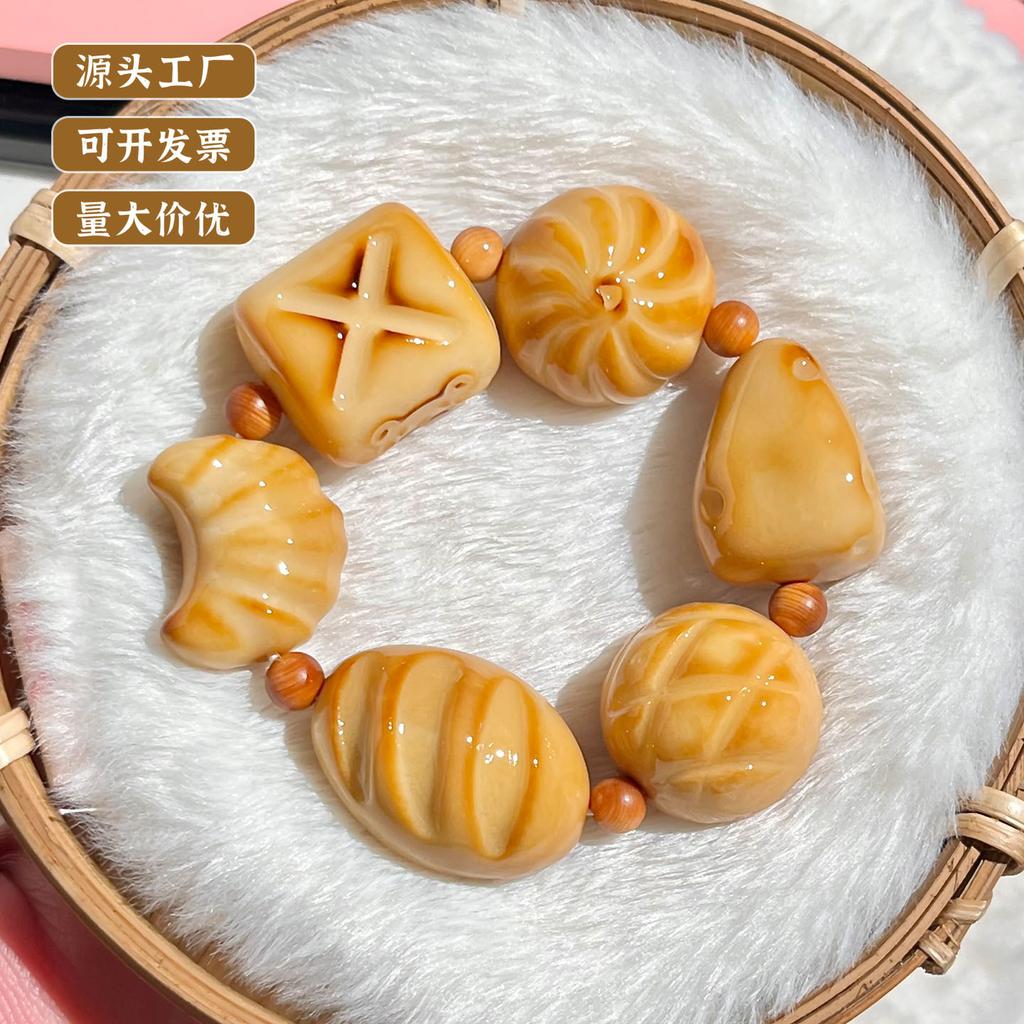 Der gleiche Stil wie der Little Red Shop: Holzkohle-gebranntes Elfenbein-Fruchtschnitzerei-Armband, süßes brotförmiges Elfenbein-Frucht-Kulturspielzeug-Armband für