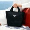 Prada Schwarze Mini-Tragetasche Make-up-Tasche Dreieckiges Metall-Logo Tragbare Hand-Kosmetik-Aufbewahrungstasche für Damen Reise Täglich