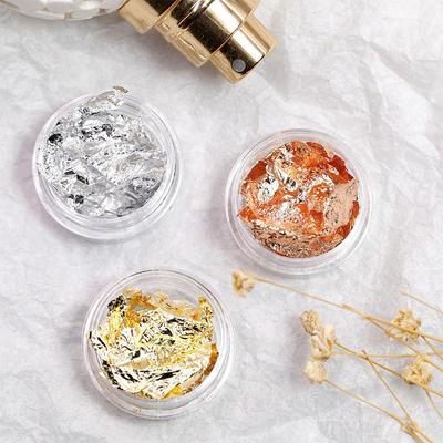 Großhandels-Nagelkunstaufkleber in Gold und Silber mit farbigen Alufolienfragmenten.