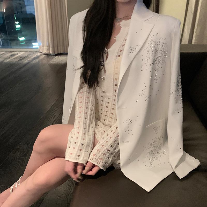 Dámské sako na galavečer s třpytivými výřezy, vycpanými rameny a lemováním.