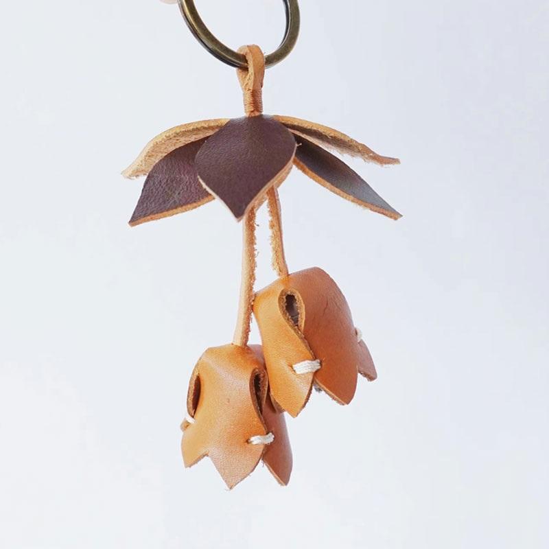 

Handmade leather keychain with unique original design in caramel brown with flowers and leaves for bag