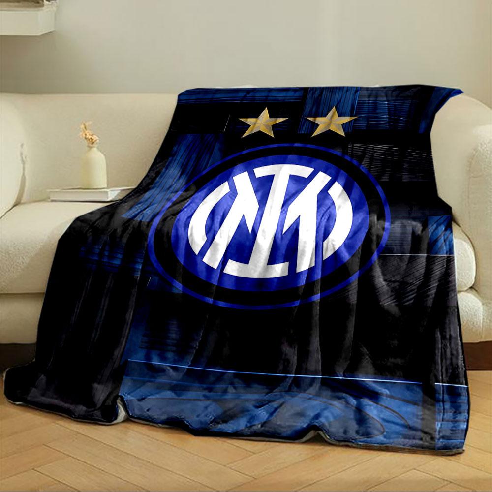 Intertwined white letters in a blue circle, two gold stars above, wood-like background. for all seasons blanket lunch break throw gift