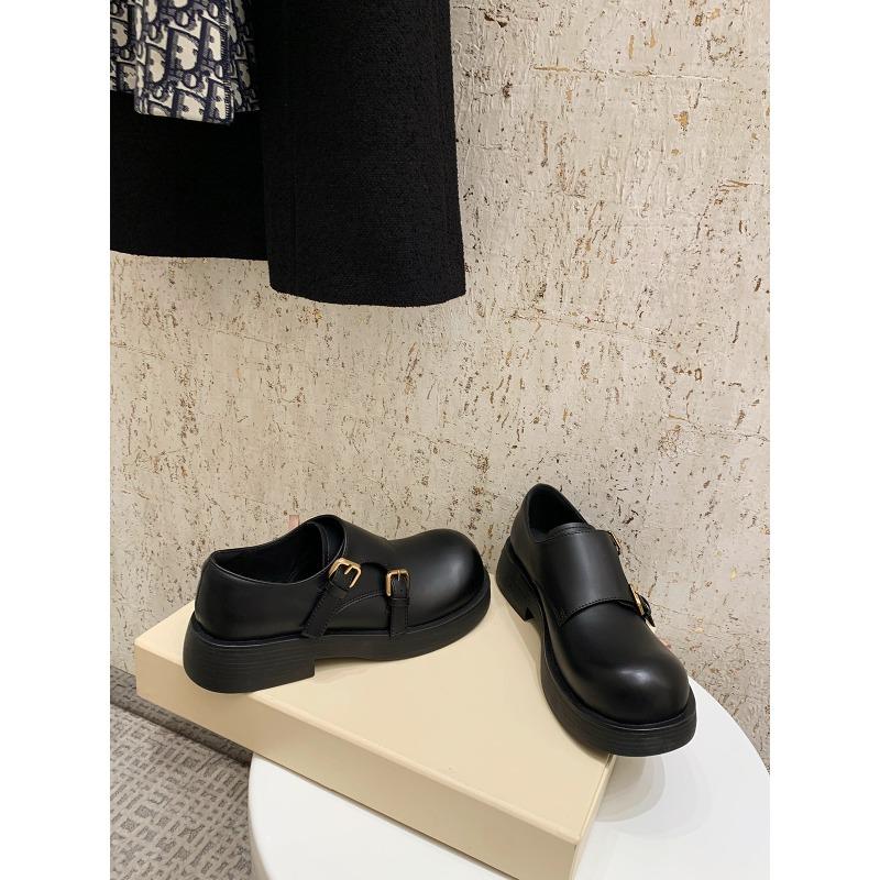 Eine Frau trägt ein Paar Retro-Schuhe mit großen Köpfen, runder Zehenpartie und rutschfesten Sohlen.