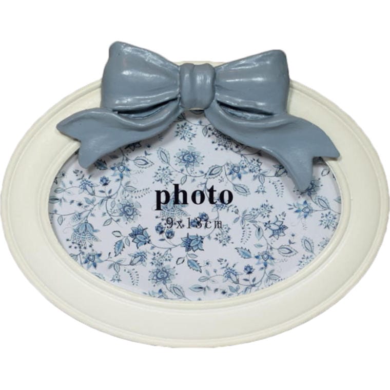 A charming white oval-shaped frame decorated with a bow