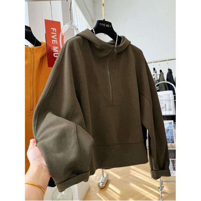 En lös, avslappnad och tillbakalutad huvförsedd tröja med halv dragkedja för kvinnor under hösten, som är extremt vacker