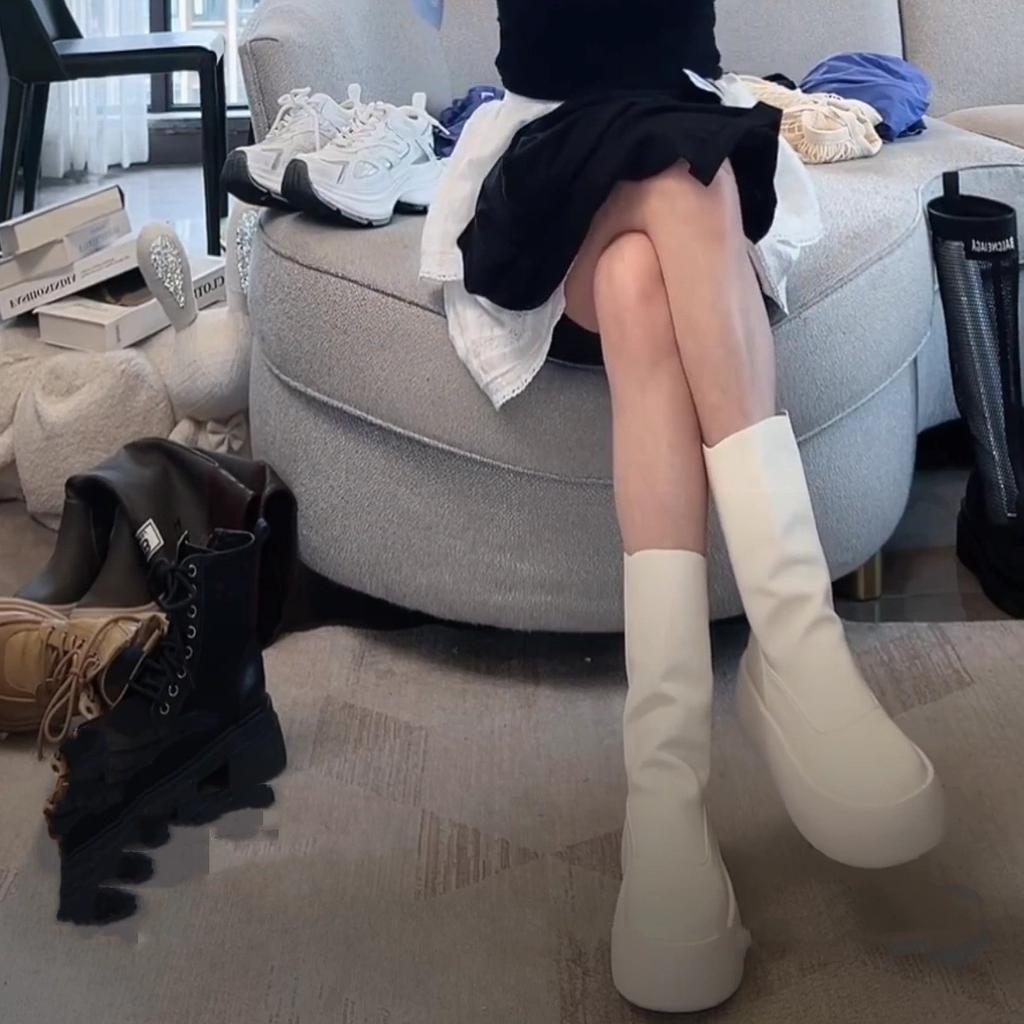 Modelka na přehlídkovém mole v minimalistickém stylu podzim 2025, cigaretové kozačky, na jeden pedál, tenké kozačky mohou být slané i sladké, korejská verze elastických kozaček na silné podrážce