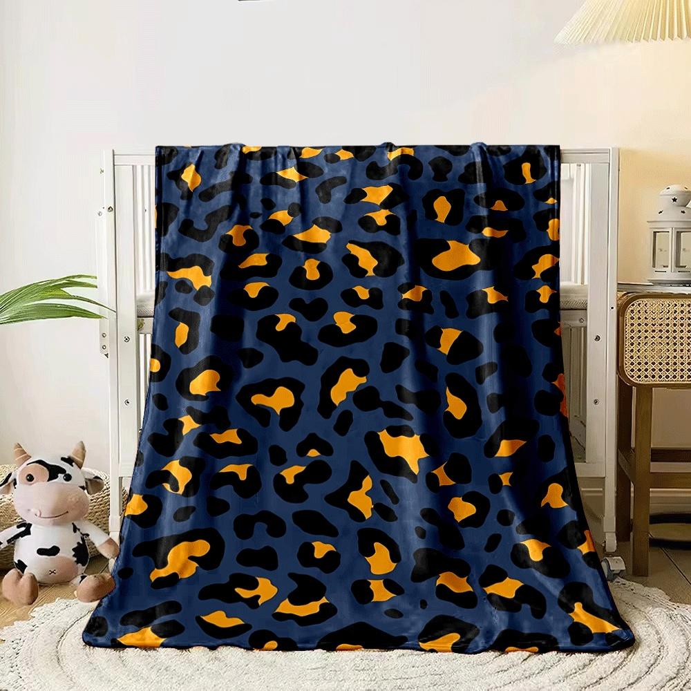 A leopard print pattern with orange and black spots on a navy background. for all seasons blanket lunch break throw gift