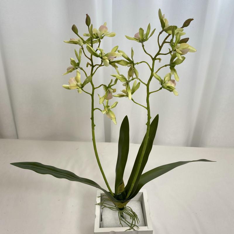 Realistische Seiden-Dendrobium-Orchidee mit Blättern für Blumengesteck auf dem Esstisch
