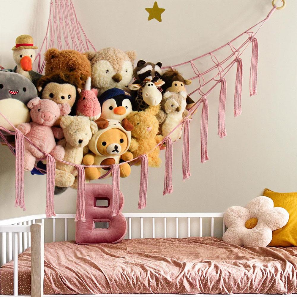 Toy hammock is hung in the corner and is equipped with a storage net, a toy storage bag, and a wall-mounted hammock.