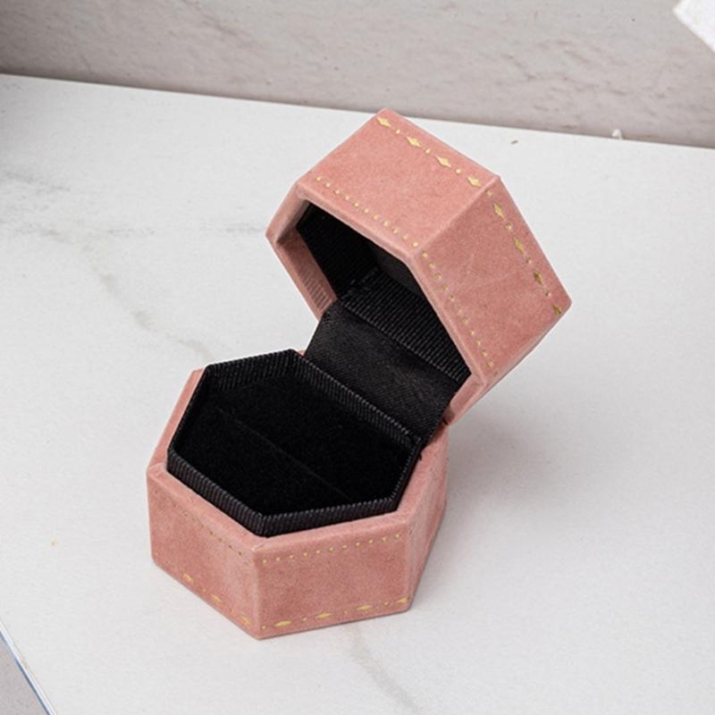 Hexagonal Ring Presentation Box with Black Interior, Gold-Tone Border Pattern, and Attached Lid for Retail Display