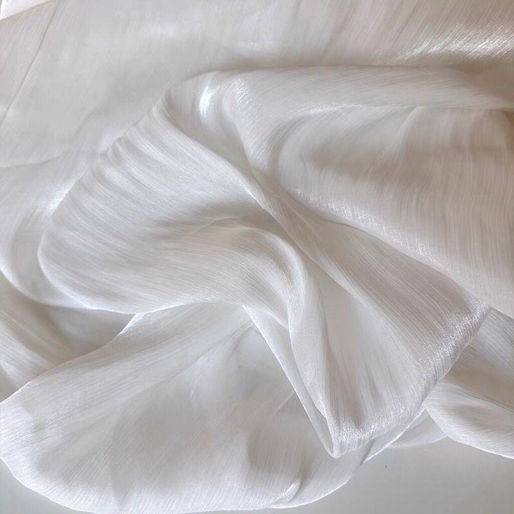 Soft shiny creased organza fabric with a smooth texture suitable for wedding dresses formal gowns and designer clothing fabrics