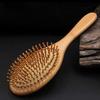 Natural wood paddle comb with bamboo bristles to detangle hair, suitable for women, men, and children, reduces frizz and massages the scalp
