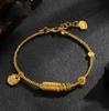 Lucky Goddess Gold-Color Ethnic Bracelet with Engraved Barrel Beads and Tibetan Rope.