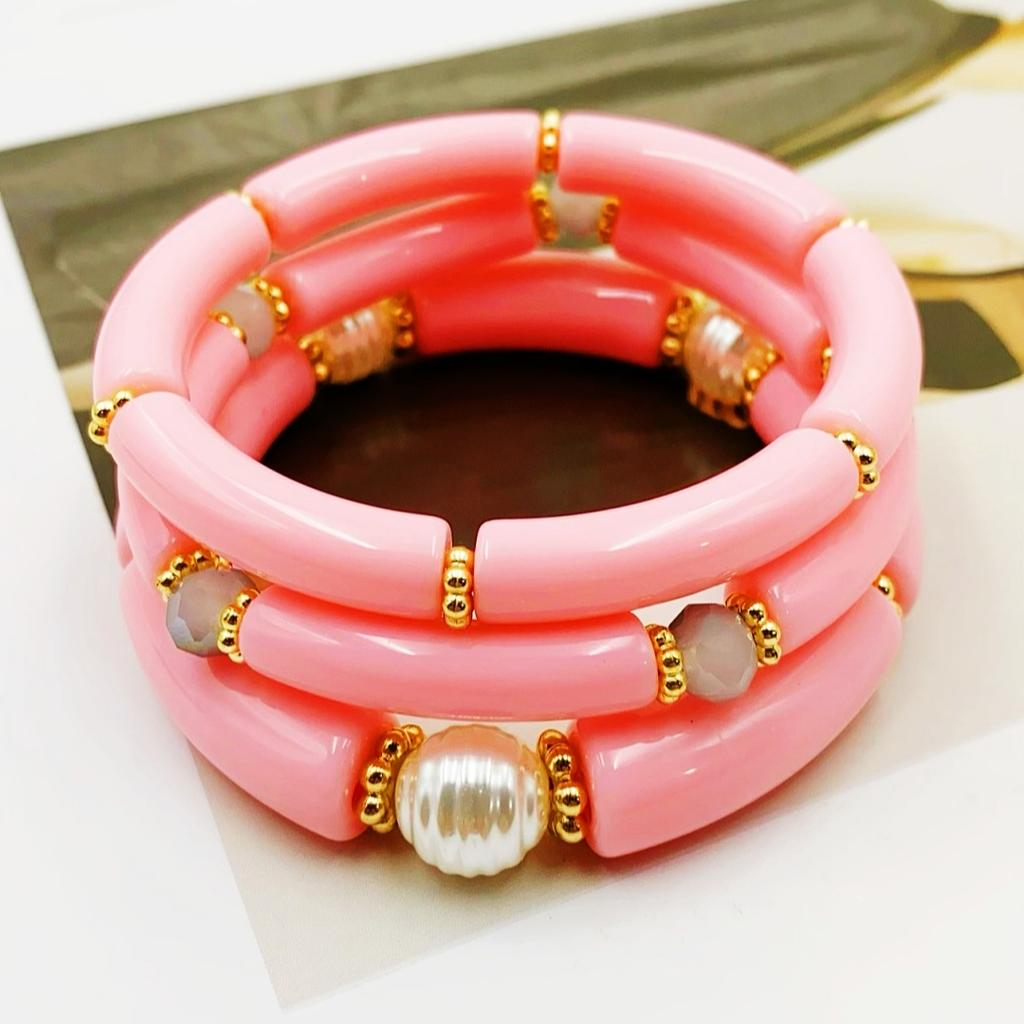 A set of three acrylic tubes connected by small golden flowers, adorned with crystal and faux pearl decorations, suitable for a lady's party.