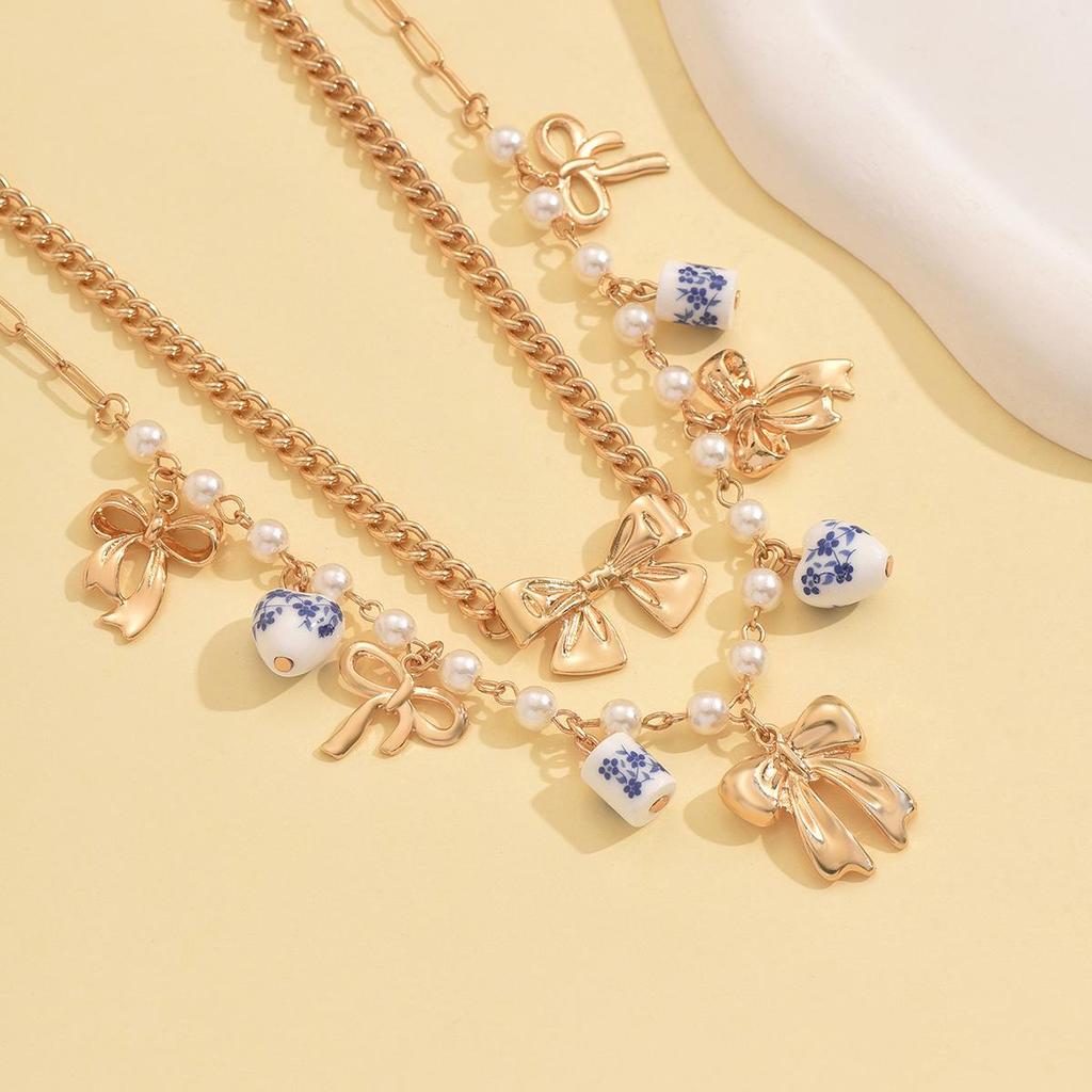 Doppellagige Perlen-Schleifen-Anhänger-Halskette - Modische Keramik-Schlüsselbeinkette